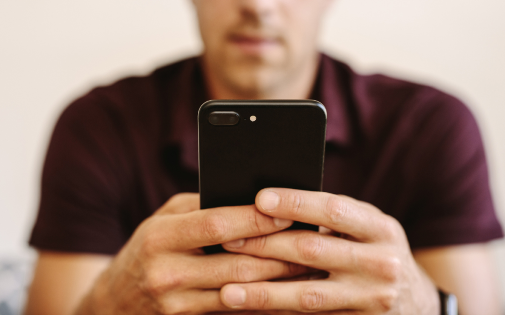 A man holding a phone comparing app store product page of Japan VS Korea