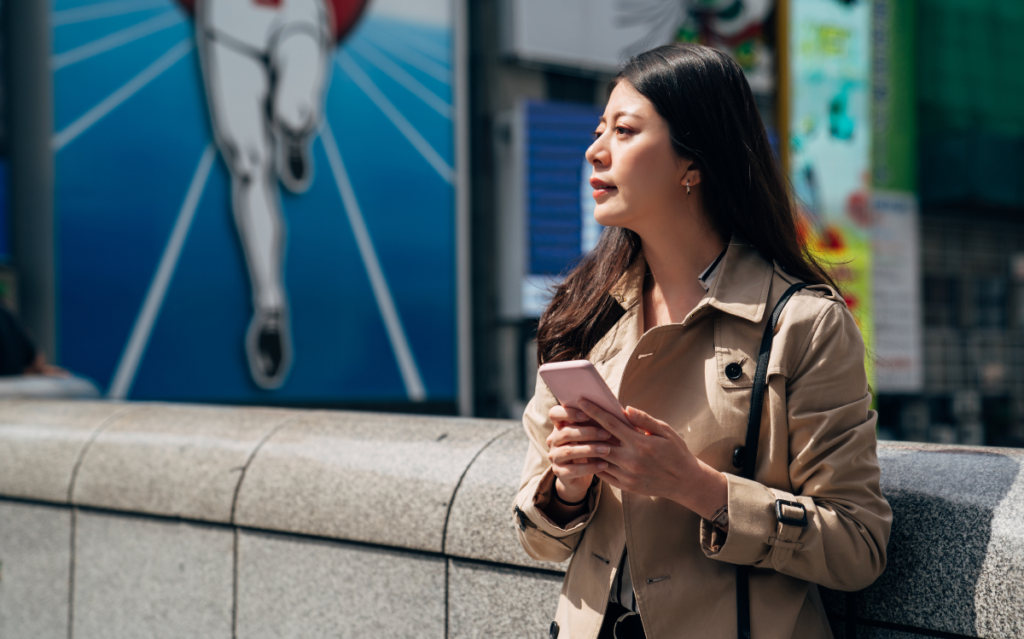 A Japanese woman holding her phone using SNS in Japan