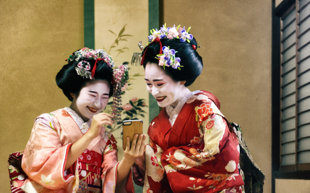 Two Japanese woman in Kimono using their mobile phone for entertainment hinting the comparison of entertainment mobile app markets in Japan and the US