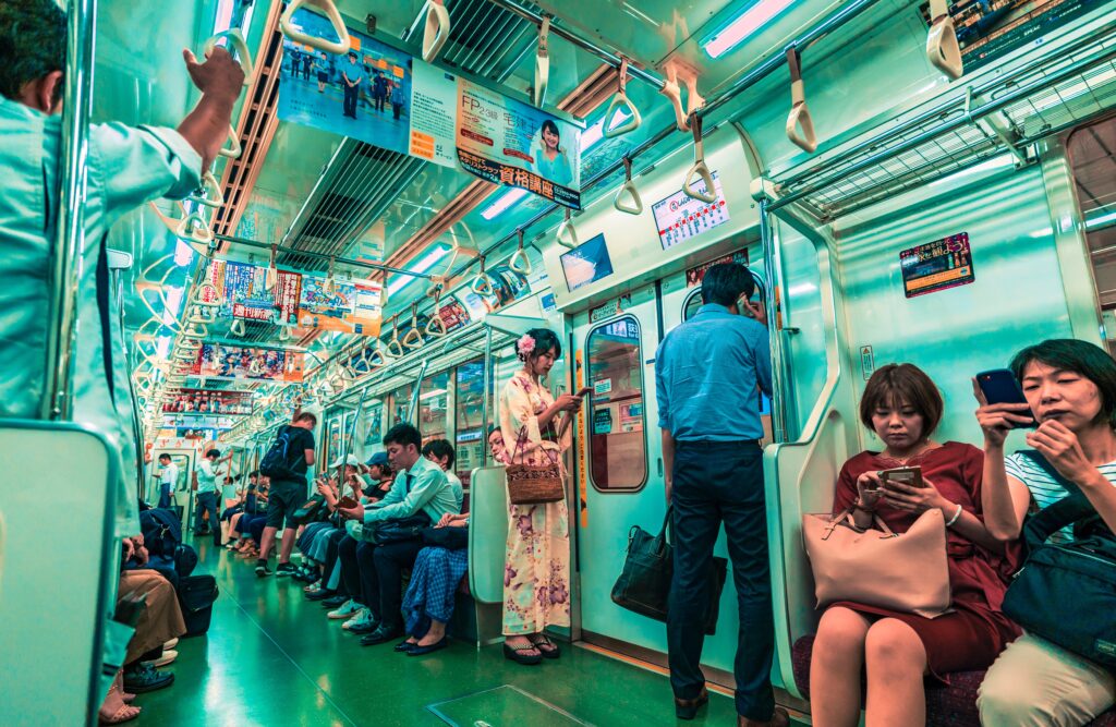 Japanese people on their phones while commuting in the train as part of the Japan mobile market